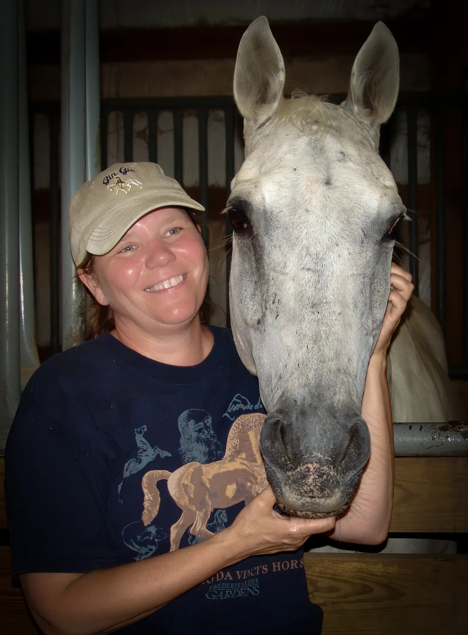 Judy Grundler standing next to her white horse. 